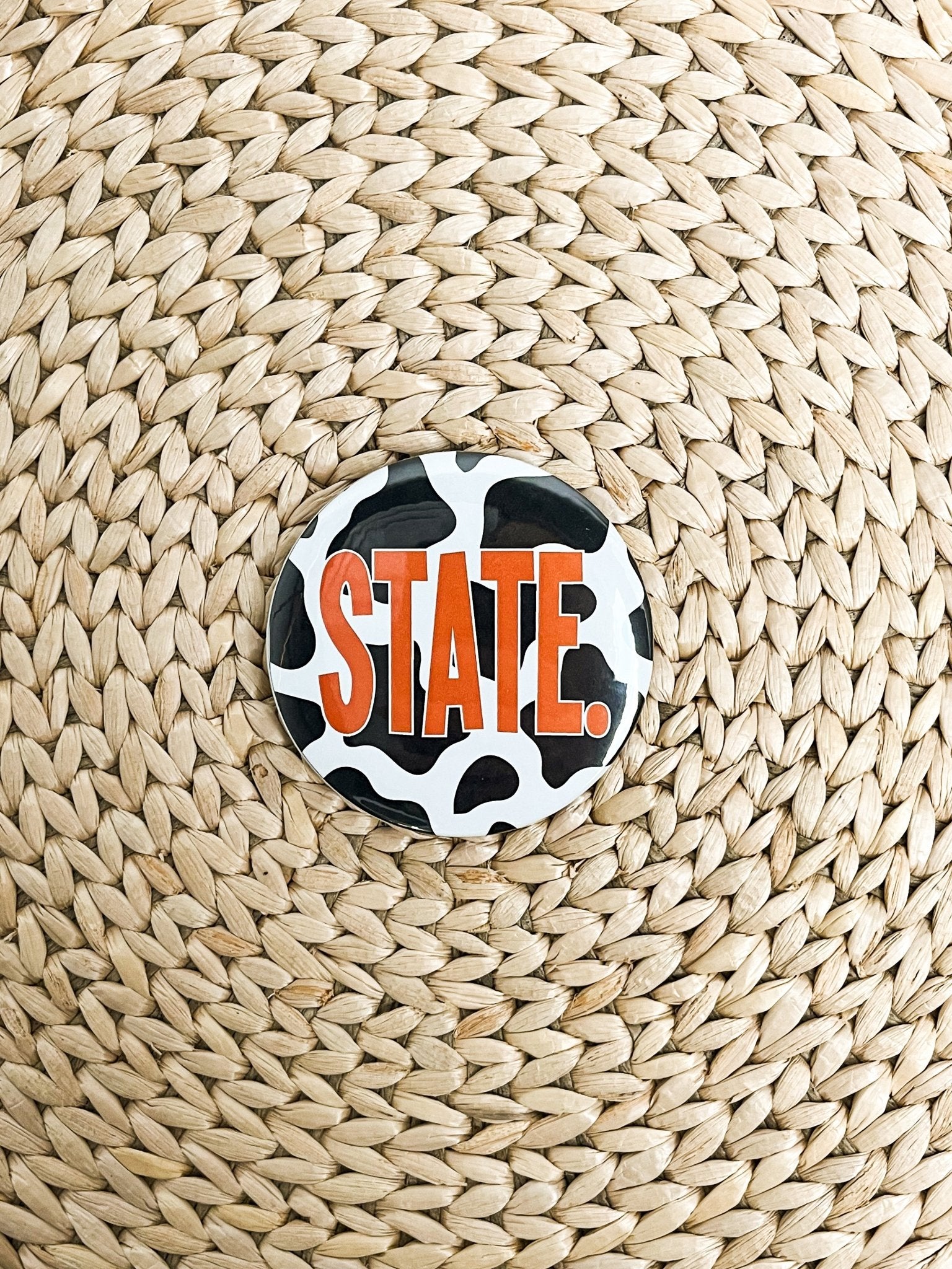 STATE. cow print 2.25 inch game day button black/white