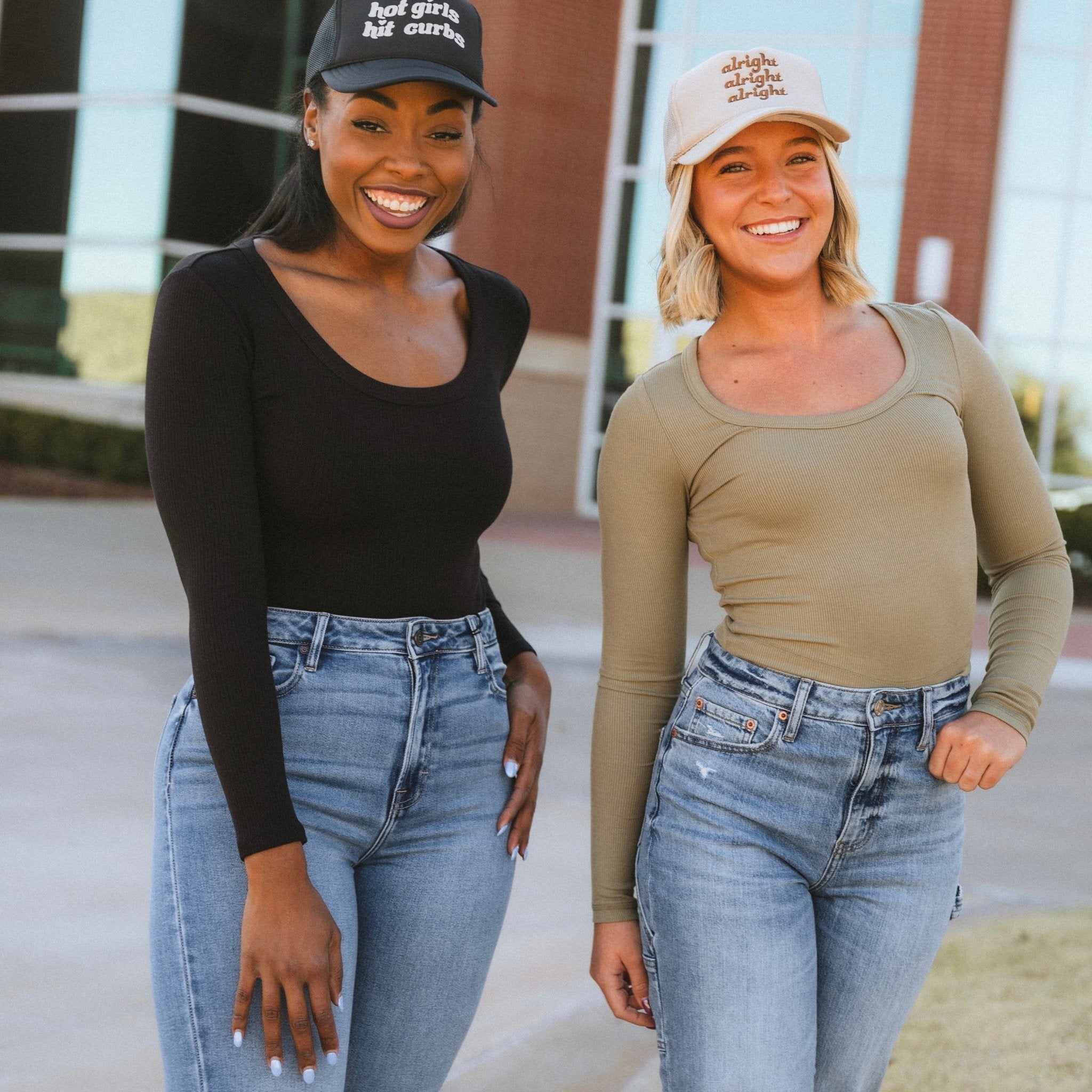 Trucker hats and basic long sleeve bodysuits on two models from Lush Fashion Lounge boutique in Oklahoma City